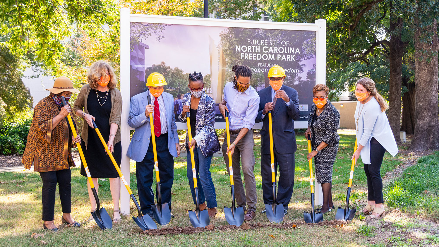 people in hard hats with shovels