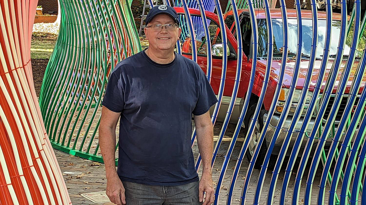 NC State graduate Matt McConnell with his "Evolution Field" sculpture in the NC State Brickyard.