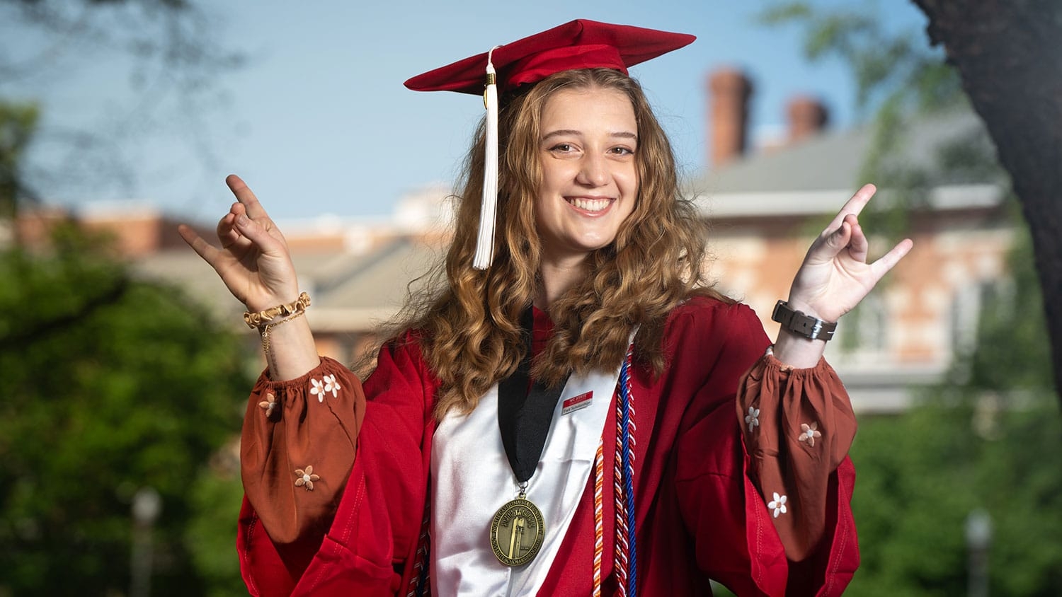 Emi Boldor, a spring 2025 NC State graduate, poses in cap and gown in the leadup to commencement.
