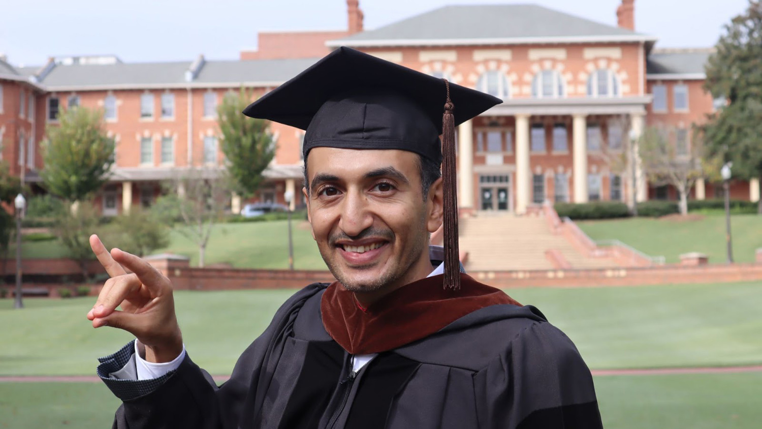 Hany Gaballa does the wolfie sign at the Court of North Carolina