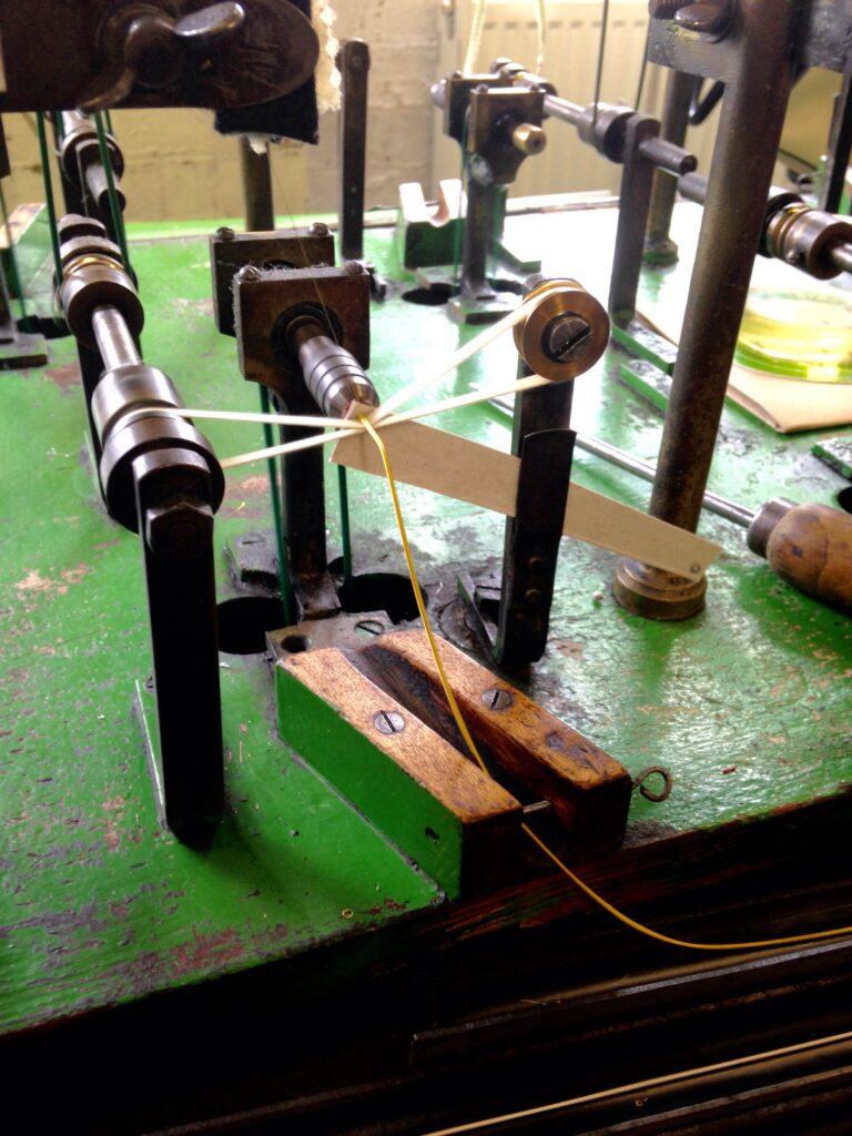 The needle spinning process of creating gold pearl purl. 