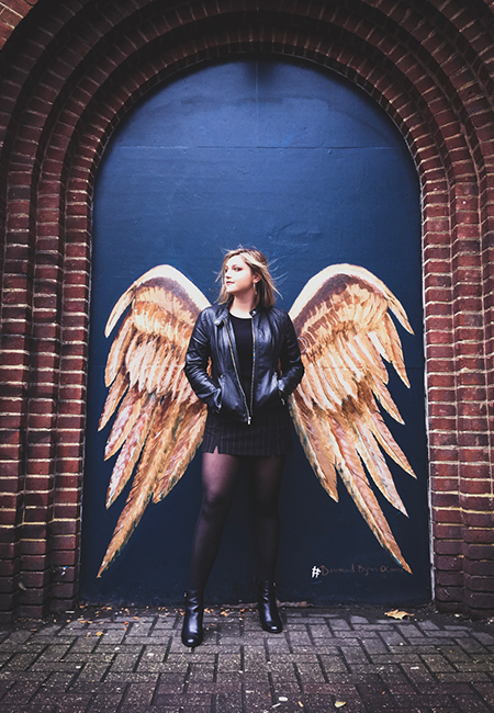Student standing in front of wings in London photo
