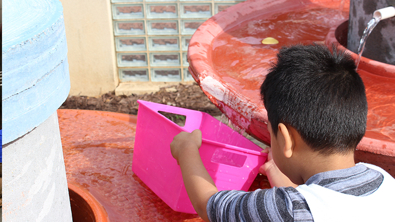 child enjoying water table