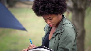 Student taking notes during an outdoor class