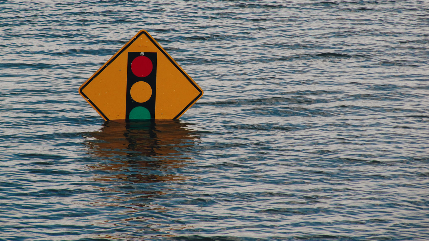 traffic sign almost completely submerged by flood waters