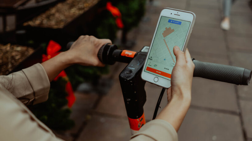 woman using Spin e-scooter and cell phone