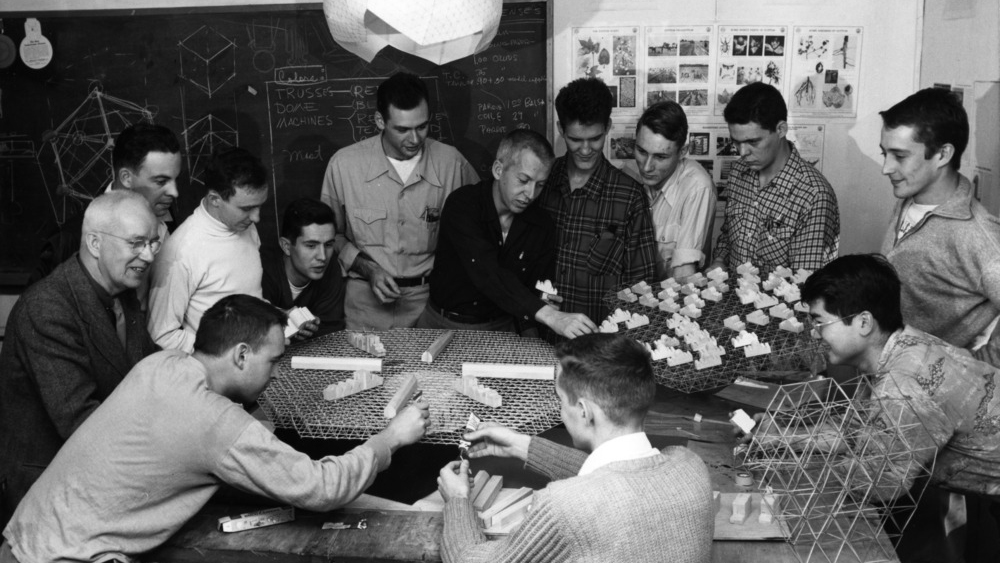 Architecture student team working with Buckminster Fuller
(center) on project to design an automated cotton mill
using the octet space frame and geodesic dome. In photo,
starting with the man in the middle standing under the
hanging object, clockwise: Ralph Knowles; Richard Leaman;
Bruno Leon; T.C. Howard; John Caldwell; Forrest Coile; Paul
Shimamoto; Fred Taylor; Sherman Pardue; Buckminster
Fuller; Jeff D. Brooks III; Ligon Flynn; Al Cameron.