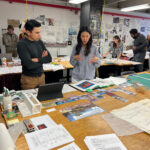 Erick Pena and a student discuss the Paper Streets project during a critique.