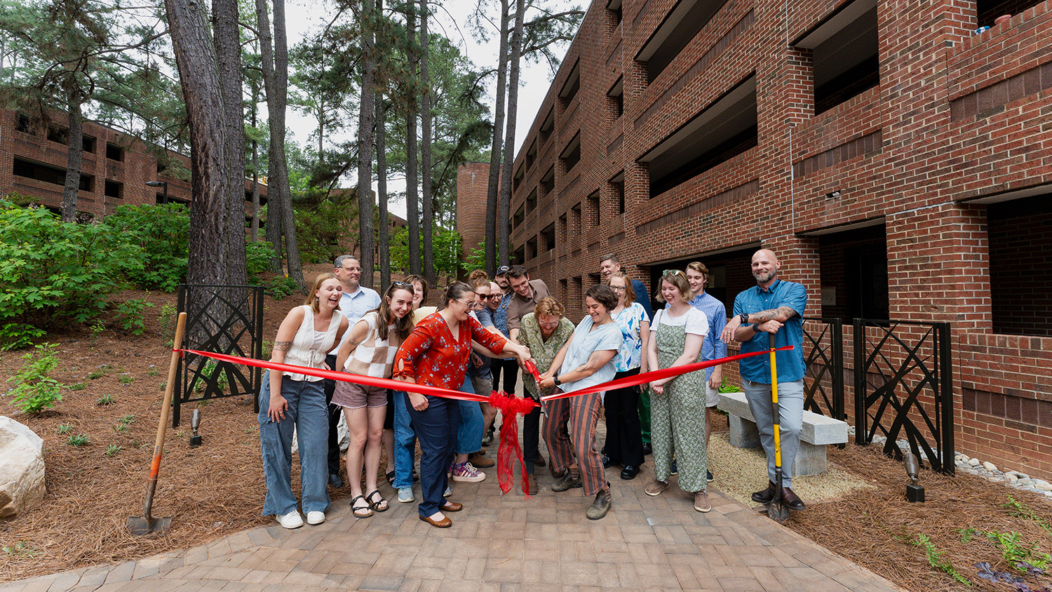 Students, professors and University Housing employees cut the ribbon on the new Wood Hall courtyard.