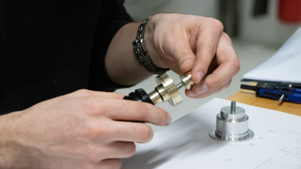 detail of Isaac working on a machined prototype