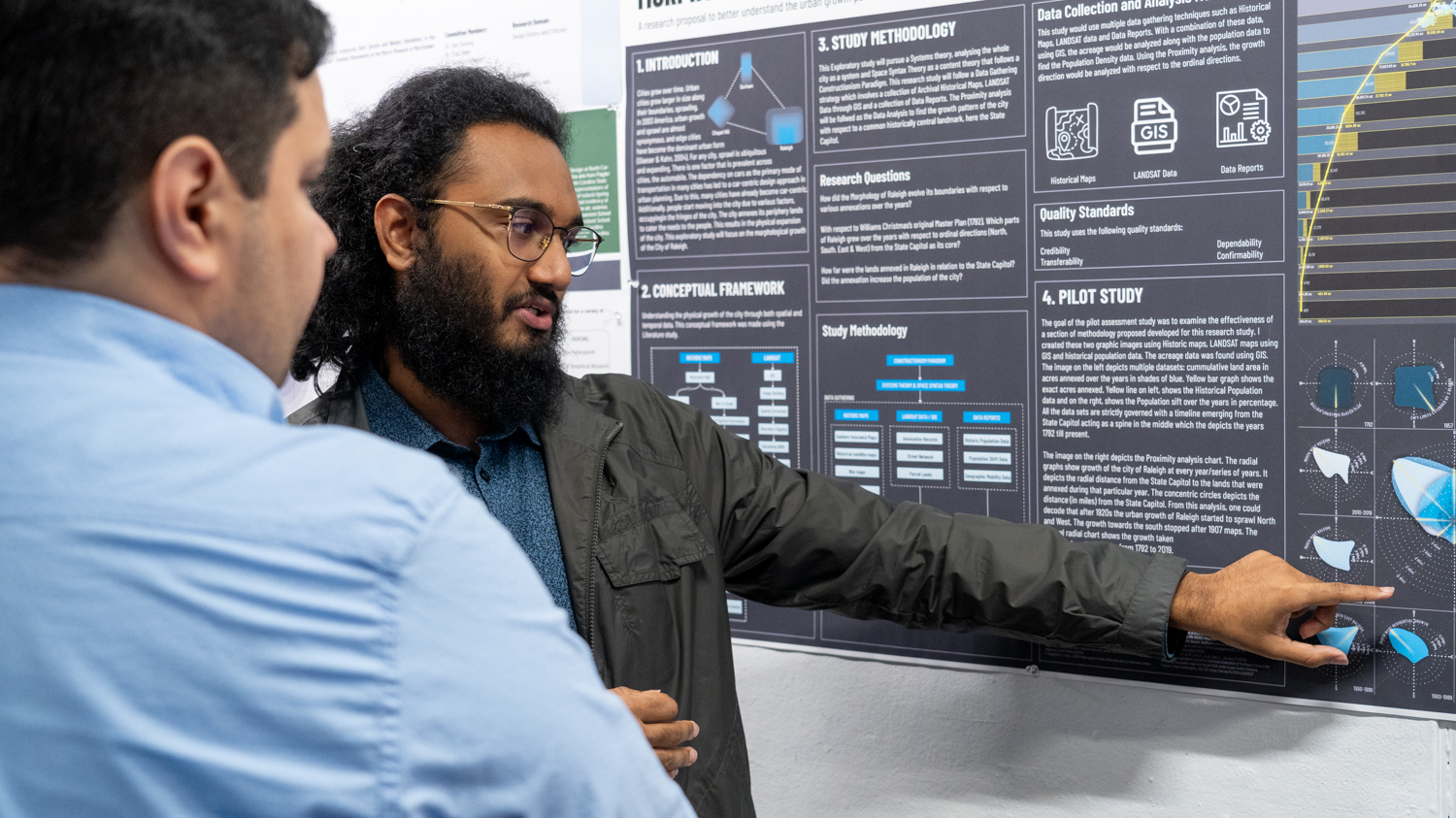 student points at poster presentation
